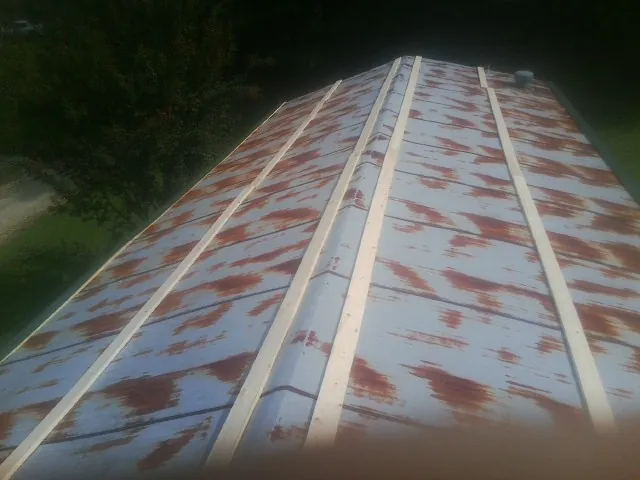 Rusted metal roof panels with new wood purlins before replacement — Storm Damage Roof Repair in Durant by Roofing Brothers